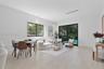 Light-filled living area featuring wood-finish flooring, recessed lighting, and expansive glass sliding doors