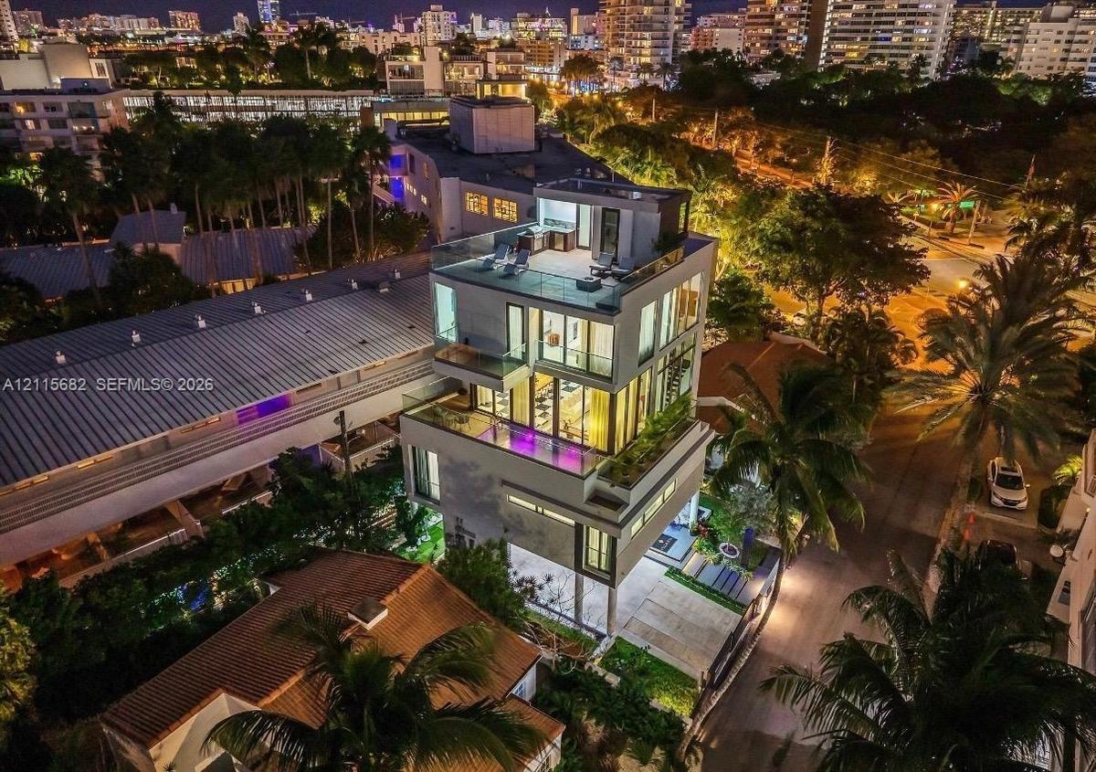 Multi-level modern residence featuring floor-to-ceiling glass windows, a private elevated pool, a rooftop terrace with an outdoor kitchen, and concret