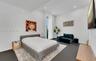 High-ceilinged room featuring large-format dark tile flooring, recessed lighting, and floor-to-ceiling sheer window treatments