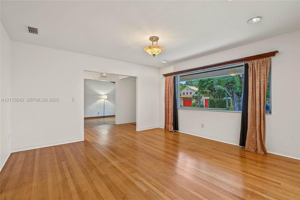 Living area featuring wood-finish flooring, recessed lighting, a decorative ceiling-mounted fixture, and a large picture window