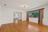 Living area featuring wood-finish flooring, recessed lighting, a decorative ceiling-mounted fixture, and a large picture window