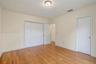 Room featuring wood-finish flooring, white paneled closet doors, and flush-mount ceiling lighting