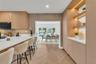 Kitchen featuring light wood cabinetry, white countertops, built-in display shelving with integrated lighting, and herringbone wood-finish flooring
