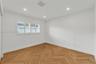 Interior room featuring wood-finish flooring in a herringbone pattern, recessed lighting, and multi-panel plantation shutters