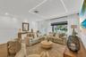 Living space featuring herringbone-pattern wood-finish flooring, recessed LED cove lighting, and floor-to-ceiling windows