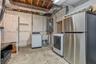 Utility area featuring a top-loading washing machine, electric dryer, stainless steel refrigerator, and integrated utility sink