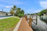Waterfront property featuring a private dock with boat lift, composite decking, swimming pool, and concrete patio