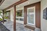 Two-car garage featuring a sectional overhead door, painted concrete flooring, white walls, and a dedicated exterior side-entry door