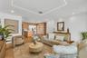 Herringbone-patterned wood-finish flooring, geometric recessed ceiling lighting, and custom light-toned cabinetry with integrated shelving