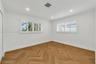 Interior room featuring wood-finish herringbone flooring, recessed lighting, and white plantation shutters