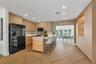 Kitchen featuring custom light wood cabinetry, white stone countertops, herringbone patterned wood-finish flooring, recessed lighting, and a center is