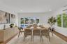 Herringbone-patterned wood-finish flooring, built-in slatted cabinetry, recessed ceiling lighting, and expansive glass paneled doors providing visibil