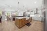 Chef's kitchen featuring plentiful storage, counter tops open to the family room and view of pool and conservation