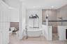 Freestanding soaking tub with floor-mounted faucet, arched window, glass-enclosed walk-in shower with tiled surround, and ceramic tile flooring