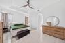 Tray ceiling featuring a central three-blade ceiling fan, large-format polished tile flooring, and an architectural arched entryway