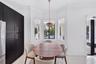 Bay window featuring large windows, matte black full-height cabinetry, large-format tile flooring, crown molding, and a drum-style pendant light fixtu