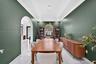 Dining area featuring high tray ceilings, polished tile flooring, a rounded archway, and a recessed window with an arched transom