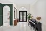 Foyer featuring large-format tile flooring, double glass-paned entry doors, a semi-circular transom window, and a decorative arched passage