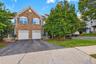 Stone veneer facade with gabled roofline, mature tree and garage
