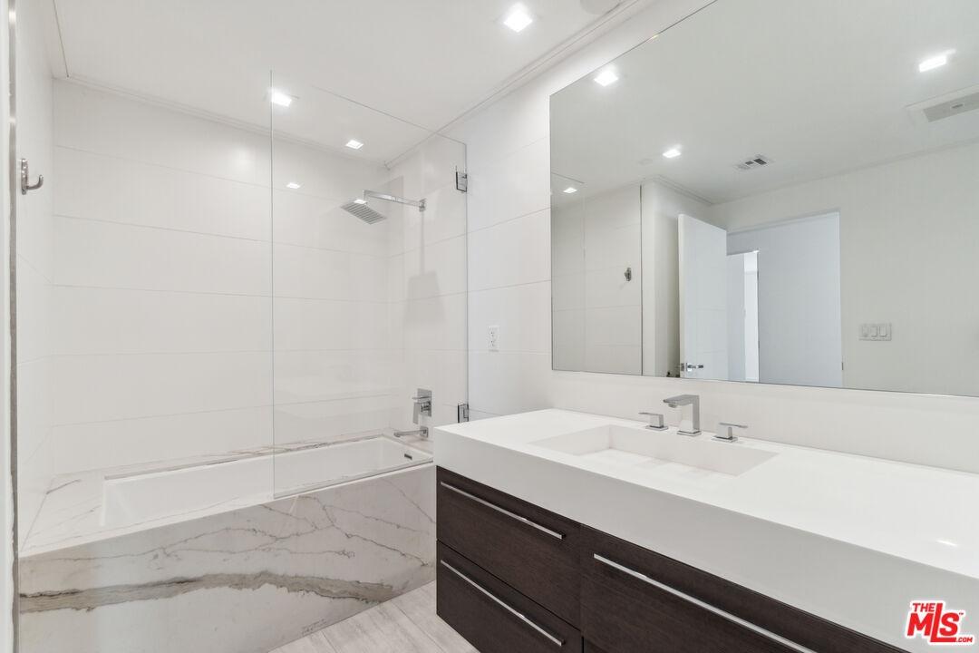 Bathroom with tub and dual van