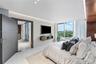 A serene primary suite with floor-to-ceiling glass, private terrace access and captivating waterfront views.