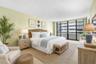 Generously scaled guest bedroom demonstrates how comfortably the second suite accommodates a full bedroom arrangement. Virtually staged; furnishings a