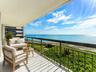 Long covered terrace runs beside the residence's broad glass frontage, emphasizing the exceptional amount of ocean-facing outdoor space.