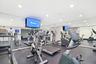 2 community fitness centers available for residents and includes cardio and strength-training equipment in a spacious mirrored workout environment.