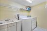 Dedicated in-unit laundry includes full-size washer and dryer, utility sink and open shelving.