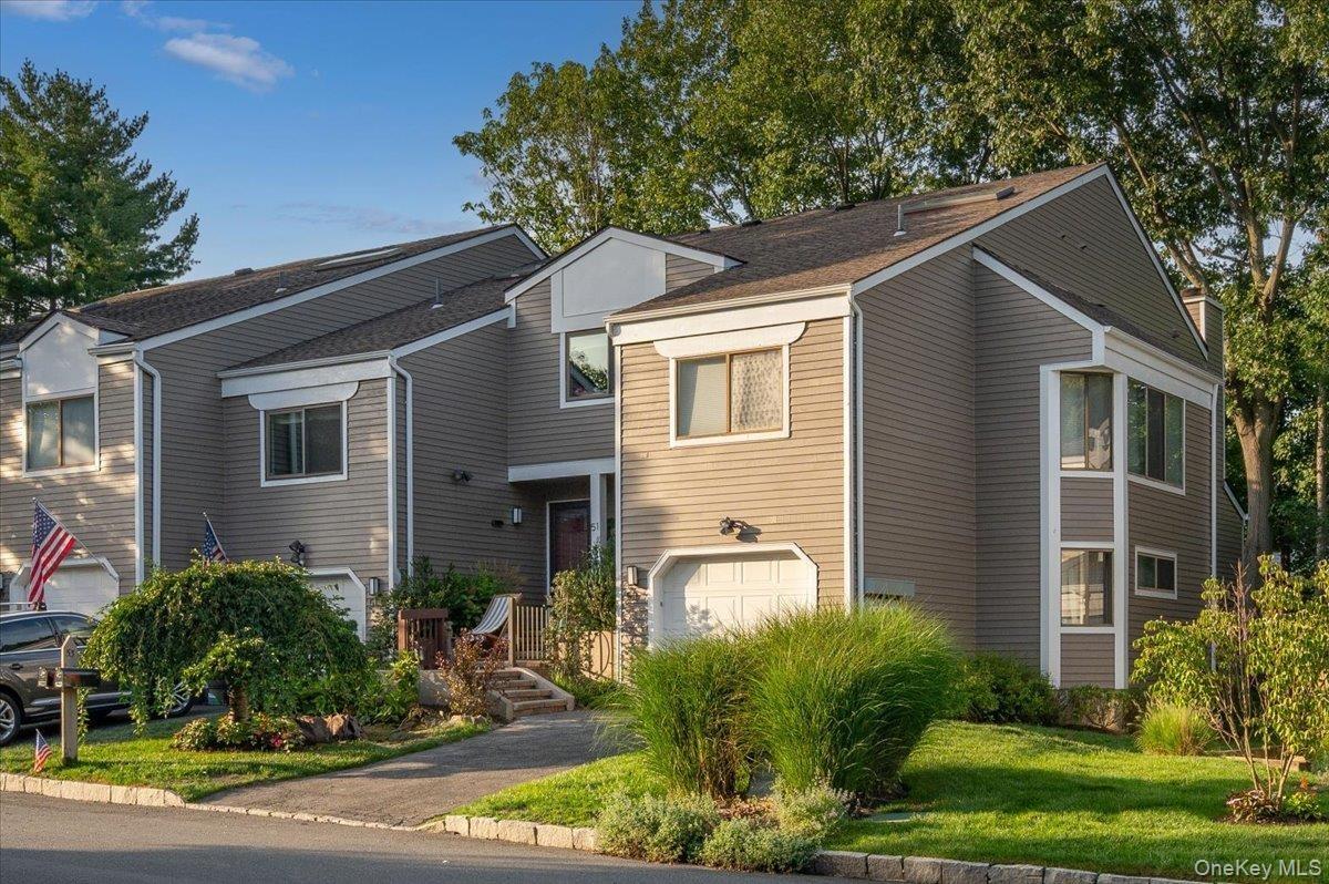 Front exterior view of this desirable end-unit townhouse, framed by mature landscaping