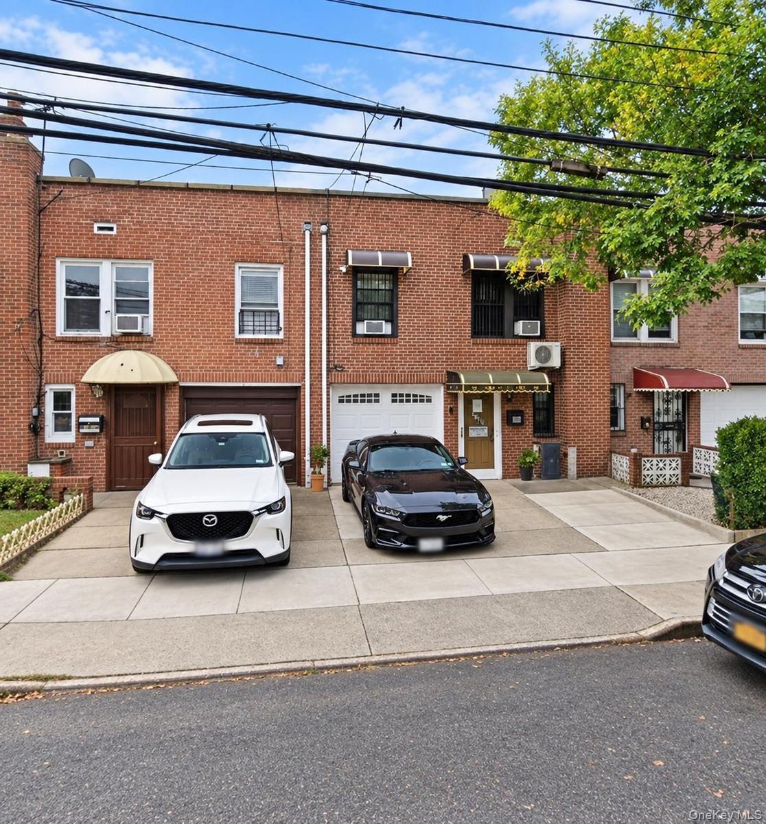 Brick facade with multiple windows, individual awnings, and integrated garage doors