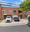 Brick facade with multiple windows, individual awnings, and integrated garage doors