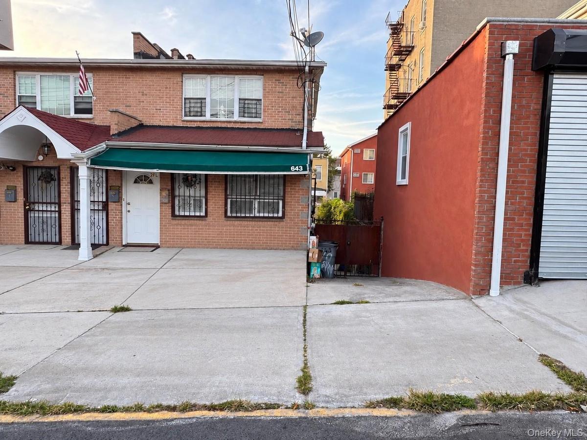 Front of House featuring long driveway and parking spaces