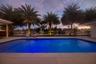 The pool, palms, dock and waterfront view at sunset