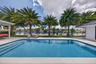 Stunning view of patio, pool, backyard, tropical landscaping, dock and waterfront