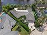 Aerial view if home with metal roof and tropical landscaping