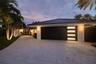 Front wide paver walkway to home, and garage and wide driveway in the evening.