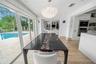 Bright breakfast area with floor-to-ceiling glass doors and beautiful pool views.