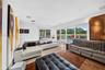 Home theater/media room with expansive glass doors overlooking the pool, lake and golf course, offering flexibility for potential use as a 5th bedroom