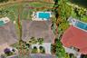 Top-down aerial view highlighting the property’s generous lot, private pool, landscaped grounds, and lake setting.
