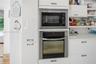 Built-in stainless-steel microwave and oven seamlessly integrated into the modern cabinetry.