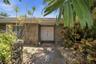 Elegant covered entrance surrounded by lush tropical landscaping, creating a warm and private welcome.