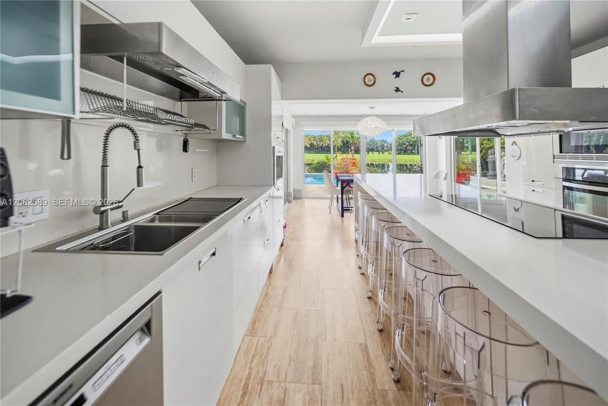Modern kitchen featuring a large center island with seating, sleek cabinetry, and stainless-steel finishes.