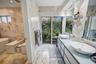Luxurious primary bathroom featuring dual vessel sinks, marble finishes, and abundant natural light.