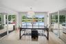 Sun-filled breakfast area showcasing panoramic pool and tranquil water views.