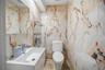 A stylish powder room featuring sleek fixtures and beautiful marble-inspired finishes.