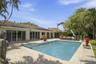 Inviting outdoor retreat featuring a private pool, spacious patio, and lush tropical surroundings.