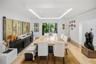 Inviting dining area featuring a spacious layout, statement lighting, and serene garden views.