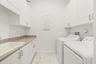 Spacious laundry room with built-in cabinetry and utility sink.