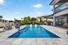 Salt chlorinated pool w/ water features, LED color changing light, sun shelf with umbrella hole and in water stools. Stone decking surrounds the pool